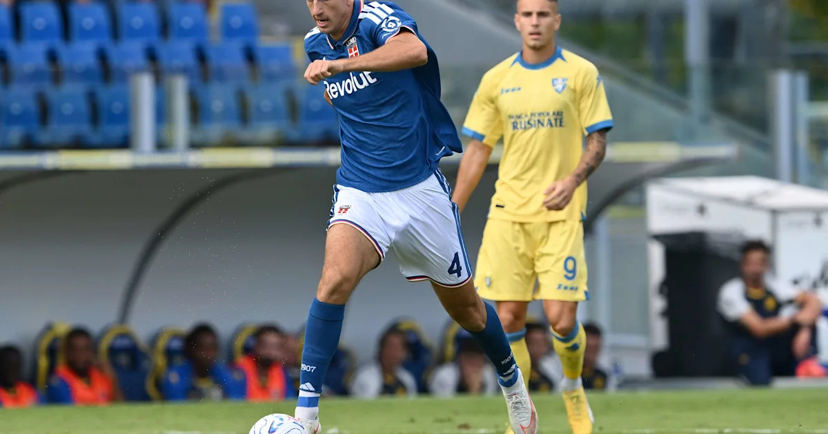 Footballer in a blue shirt and white shorts runs past an opponent in yellow.
