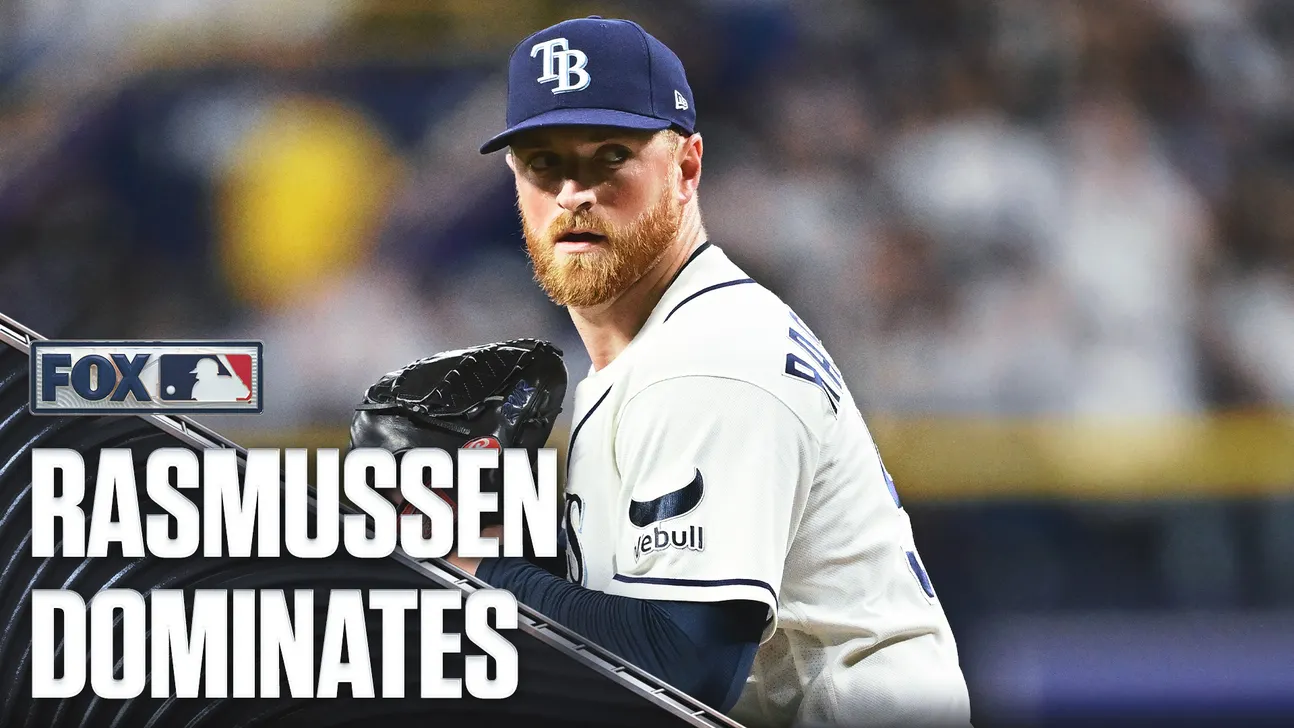 A Tampa Bay Rays pitcher in a navy cap and white uniform holds a glove during a game.