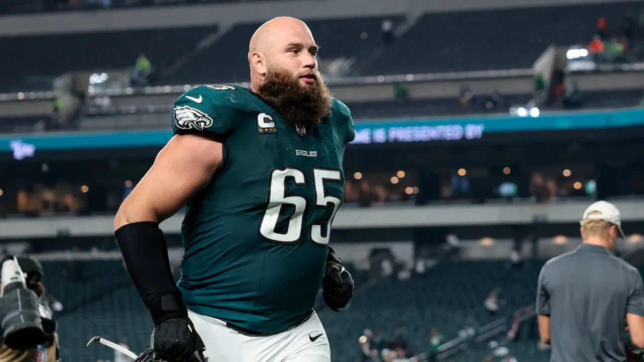 Philadelphia Eagles player wearing number 65 walks on the field in a green uniform.