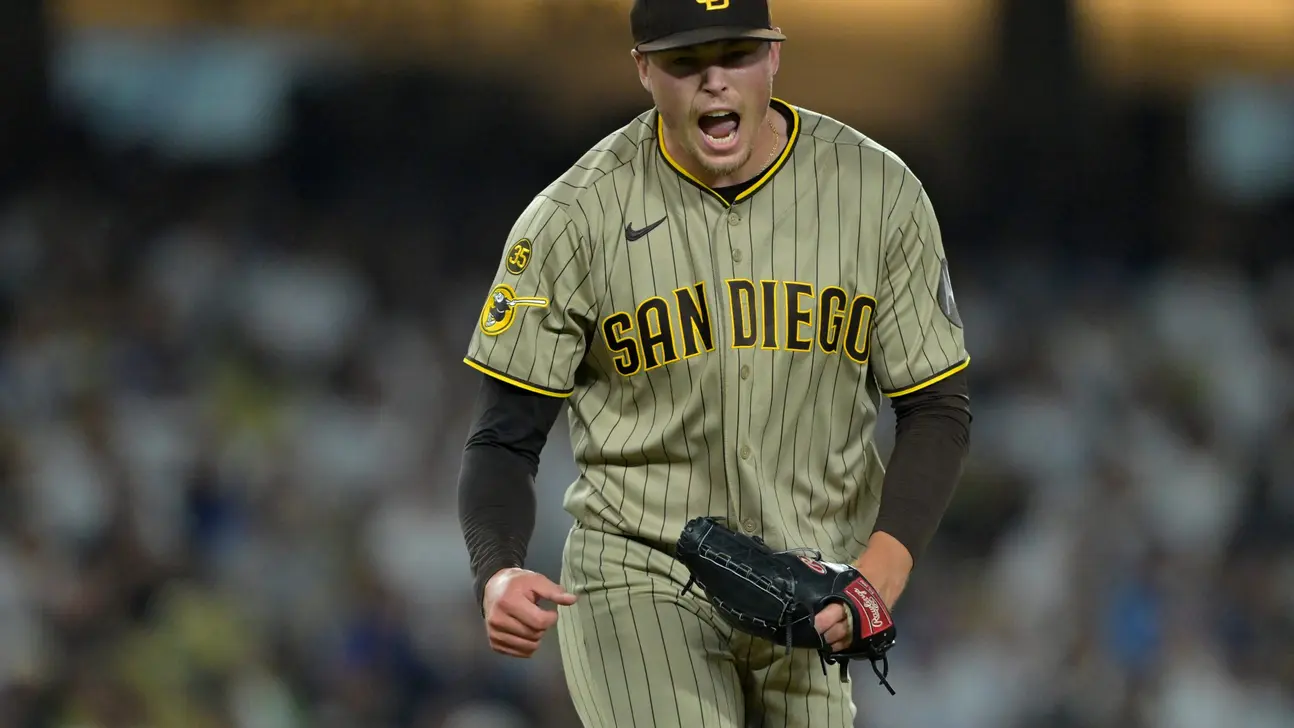 A San Diego pitcher in a pinstriped uniform shouts while holding a black glove.