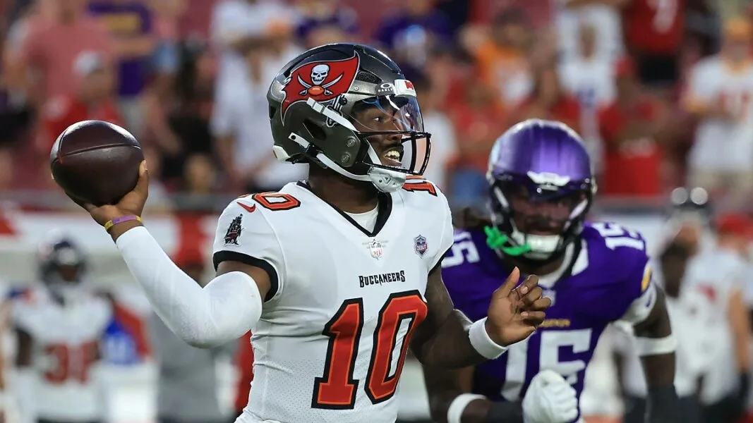 Buccaneers quarterback number 10 prepares to throw as a Vikings defender closes in.