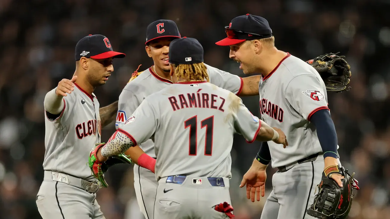 Four Cleveland Guardians players gather on the field, with one player wearing a jersey marked Ramírez 11.
