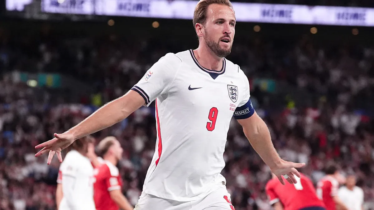 England player in a white number 9 shirt spreads his arms during a football match.