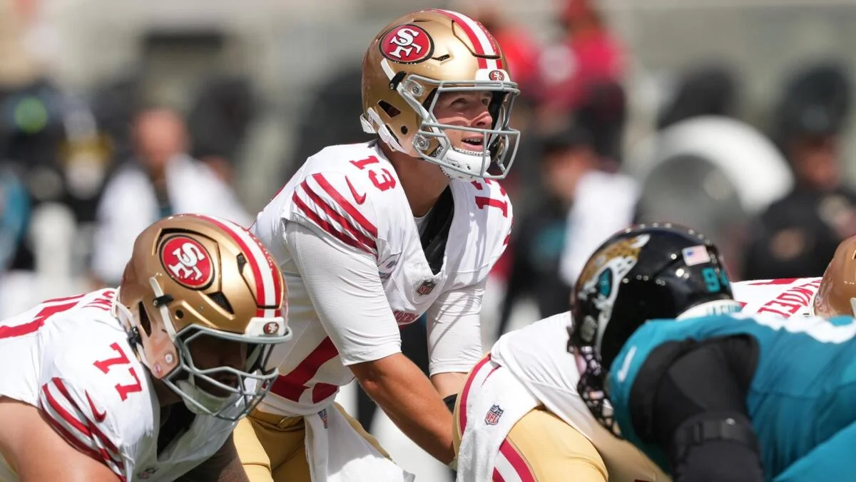 San Francisco 49ers quarterback crouches behind his offensive line before the snap against Jacksonville defenders.