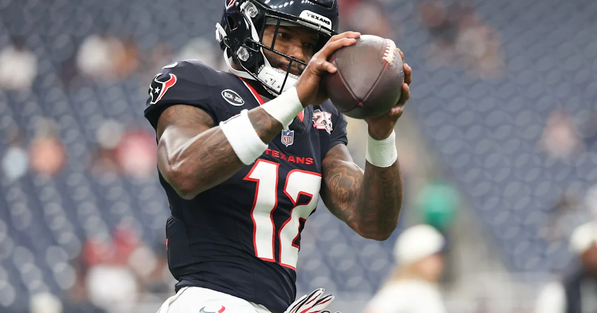 Houston Texans player wearing number 12 holds a football during a game.