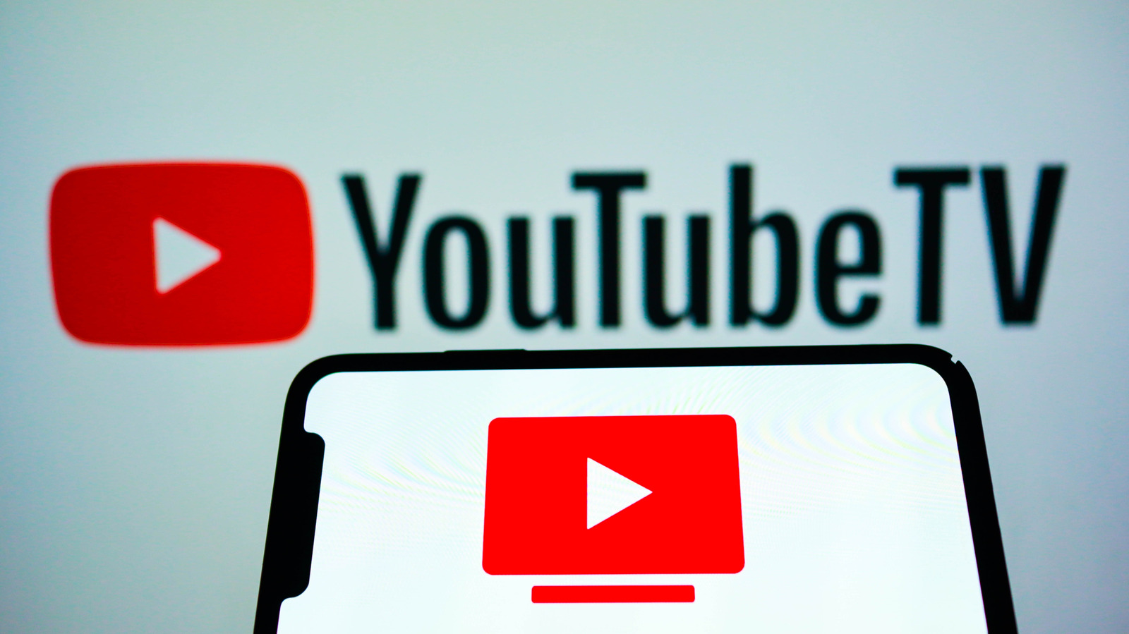 YouTube TV logo appears above a smartphone displaying the service’s red play-button icon.