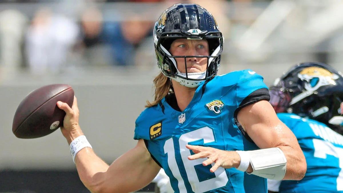Jacksonville Jaguars quarterback in a teal uniform prepares to throw a football during a game.