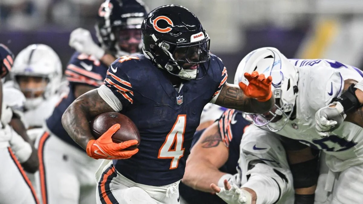Chicago Bears player in navy uniform runs with the ball as Indianapolis Colts defenders close in.