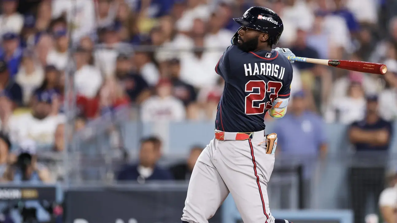 Atlanta Braves batter in a navy jersey and helmet swings a bat during a baseball game.