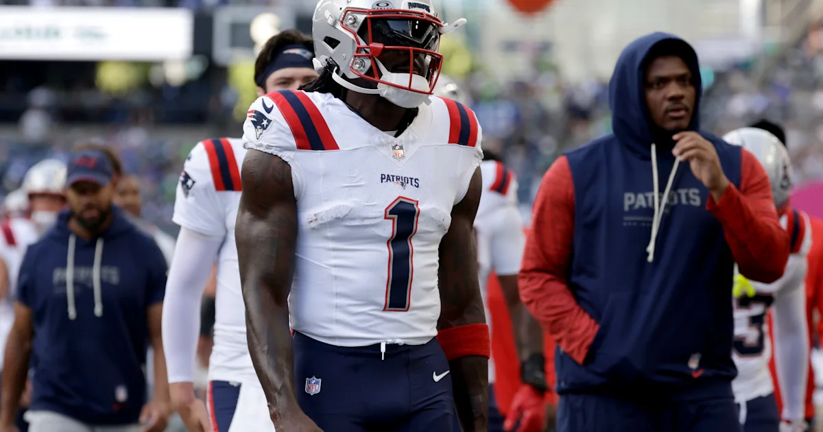 Patriots player wearing number 1 walks on the sideline in a white uniform and helmet.