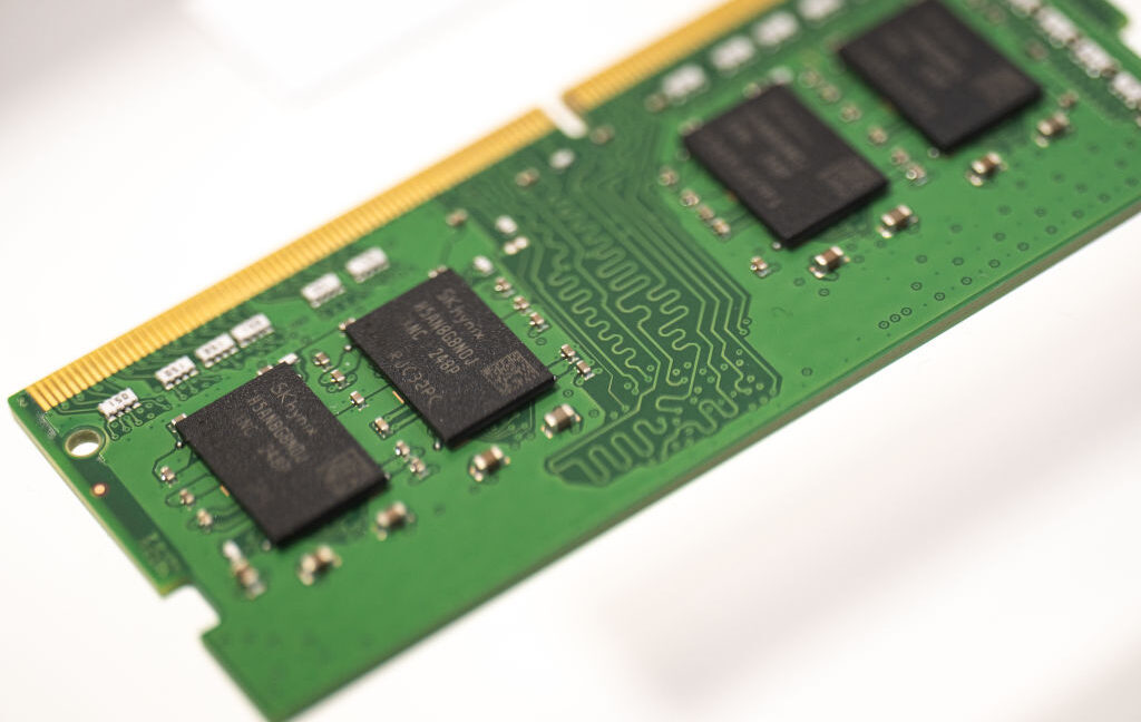 Close-up of green memory module circuit boards with black chips and gold connector contacts.