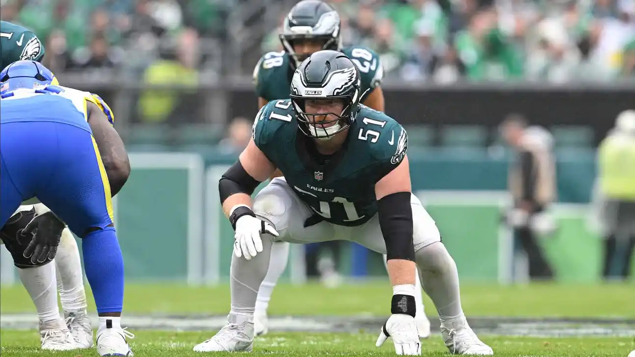 Philadelphia Eagles lineman crouches before a play as a Los Angeles Rams player lines up opposite him.