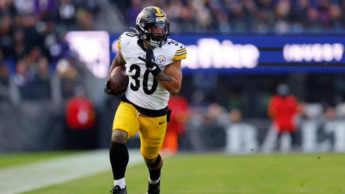 Pittsburgh Steelers player in a white number 30 jersey runs with the football.