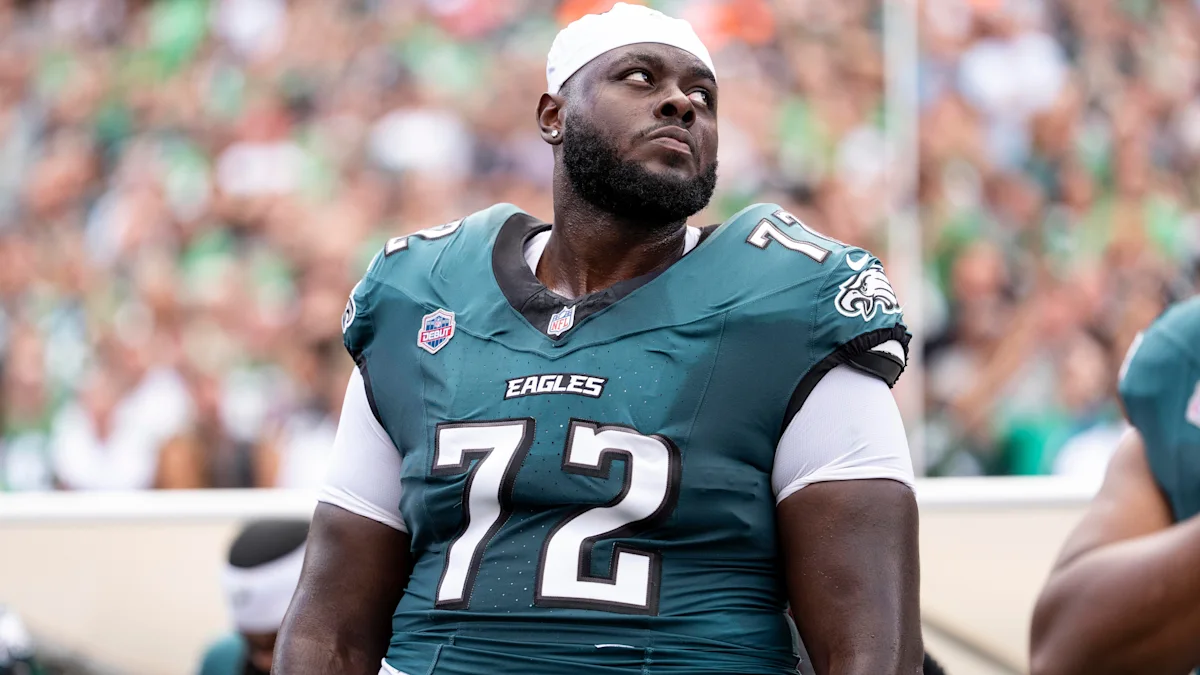 Philadelphia Eagles player wearing a teal number 72 jersey and white head covering on the sideline.