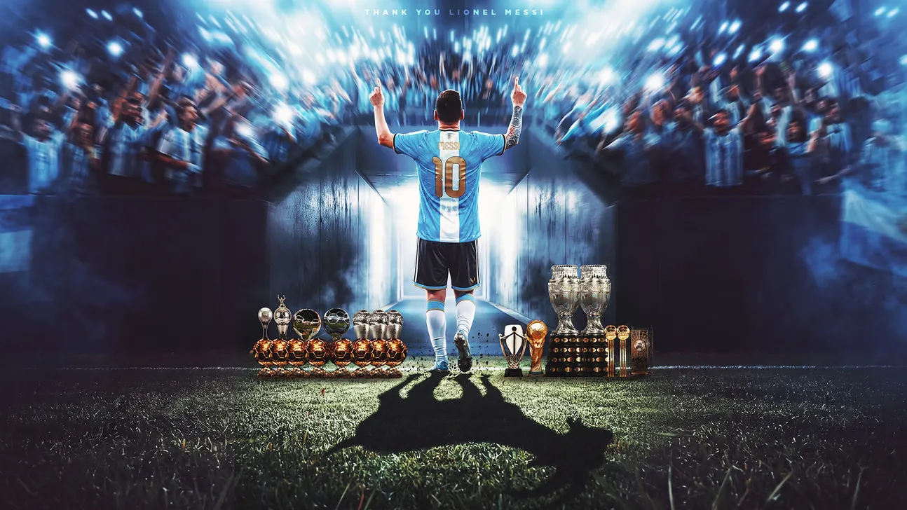 A footballer in a number 10 jersey raises both arms toward stadium stands, trophies arranged on the pitch.