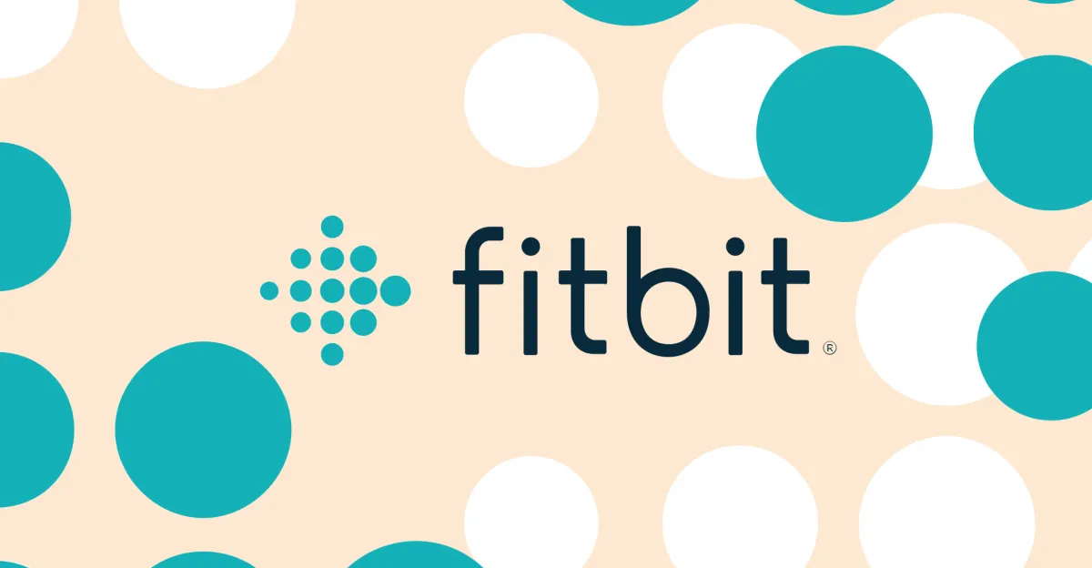 Fitbit logo centered on a pale peach background patterned with teal and white circles.