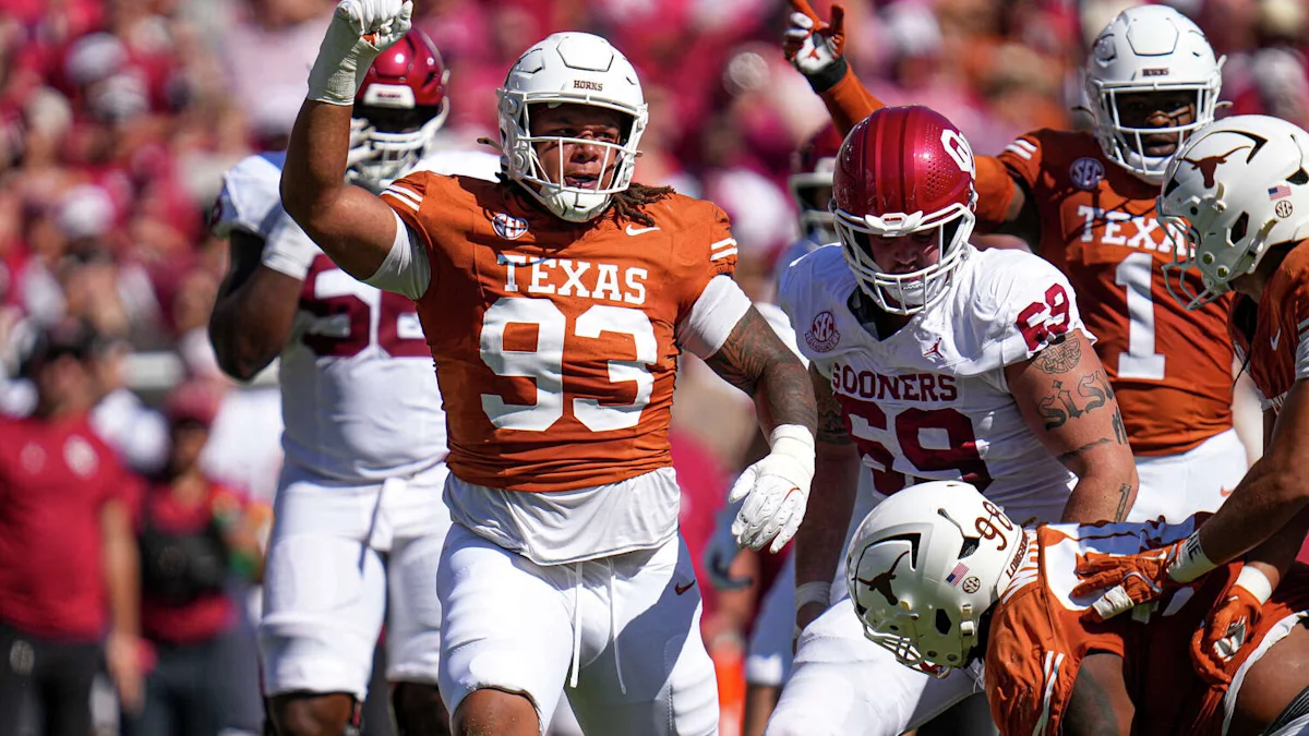 Texas players in burnt orange celebrate as Oklahoma players in white stand nearby during a football game.