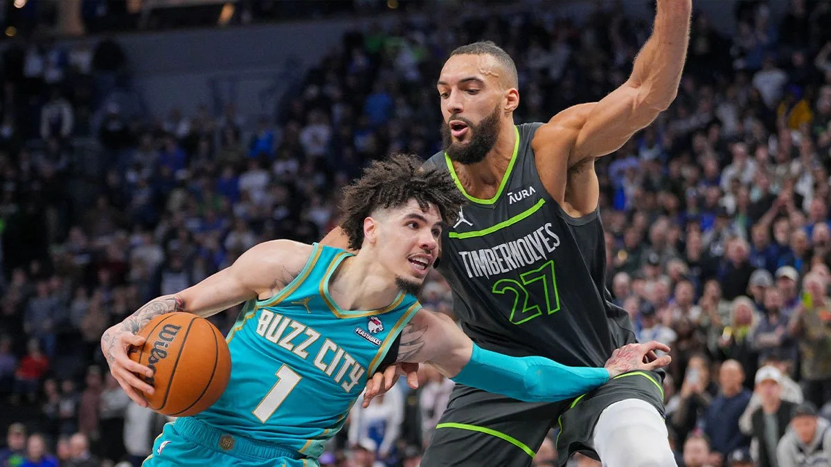A Charlotte player drives with the ball as a Minnesota defender raises an arm beside him.