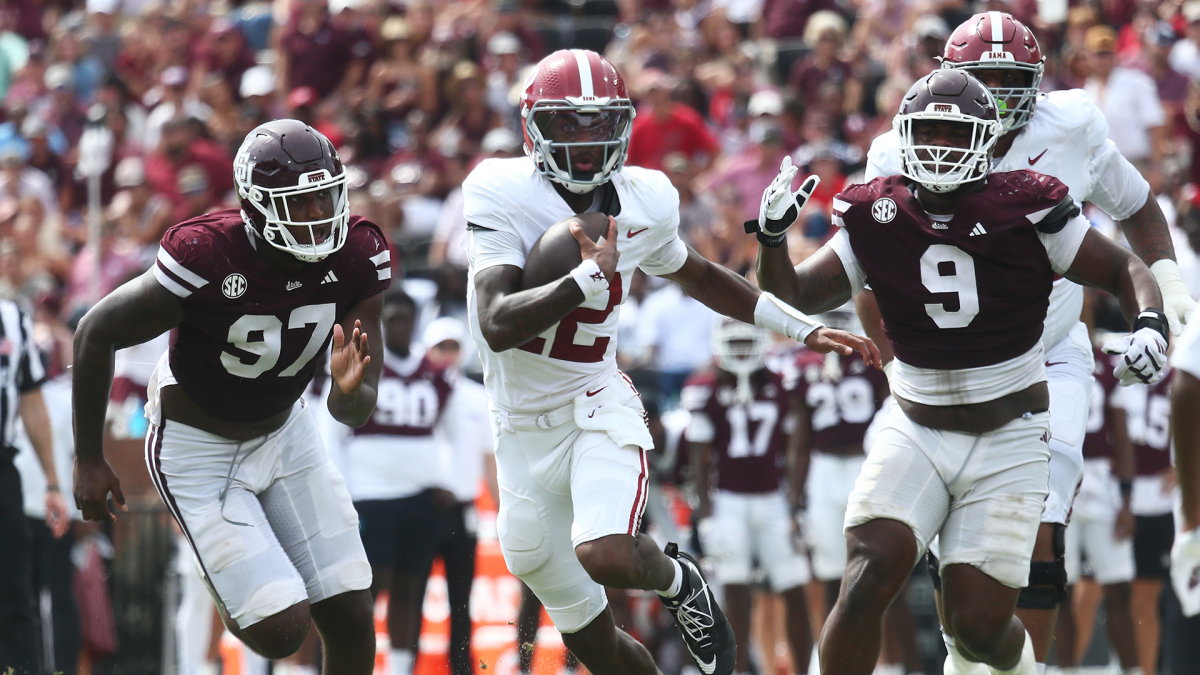 Football players in maroon and white chase an Alabama player carrying the ball during a game.