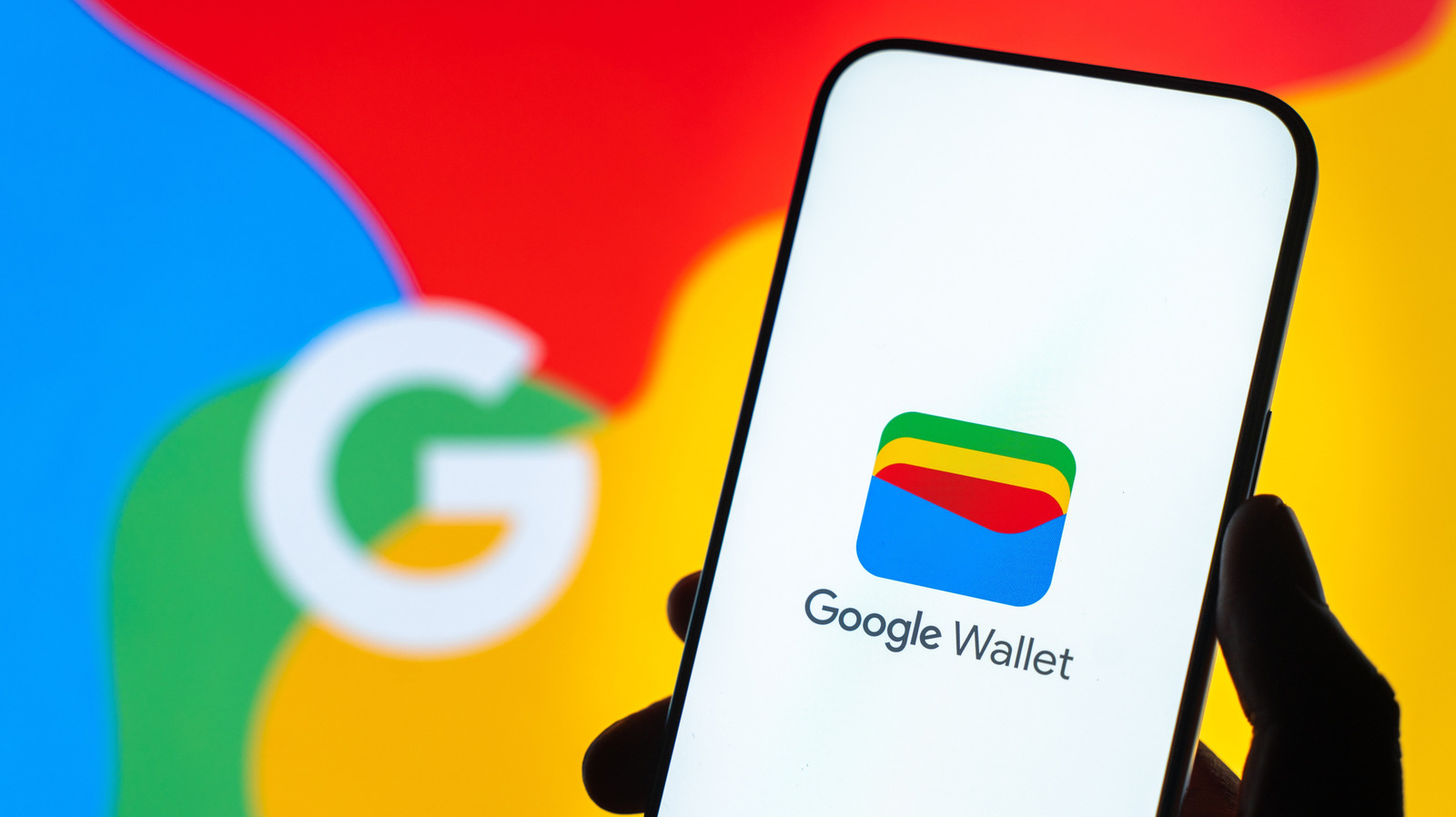 A hand holds a phone displaying the Google Wallet logo against a colorful Google-themed background.