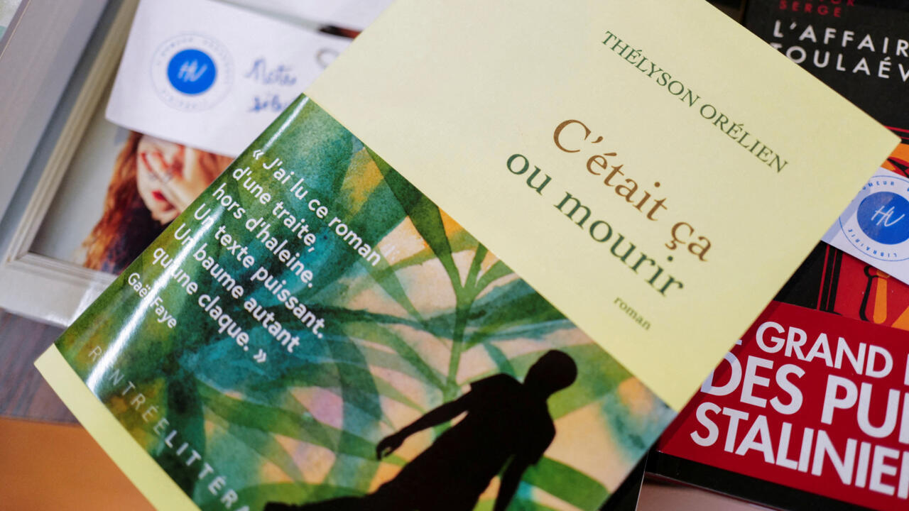 A French novel titled « C’était ça ou mourir » lies across other books and magazines.