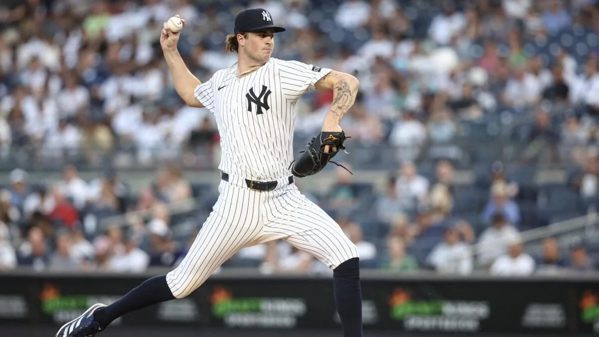 A Yankees pitcher in a pinstriped uniform winds up to throw a baseball on the mound.